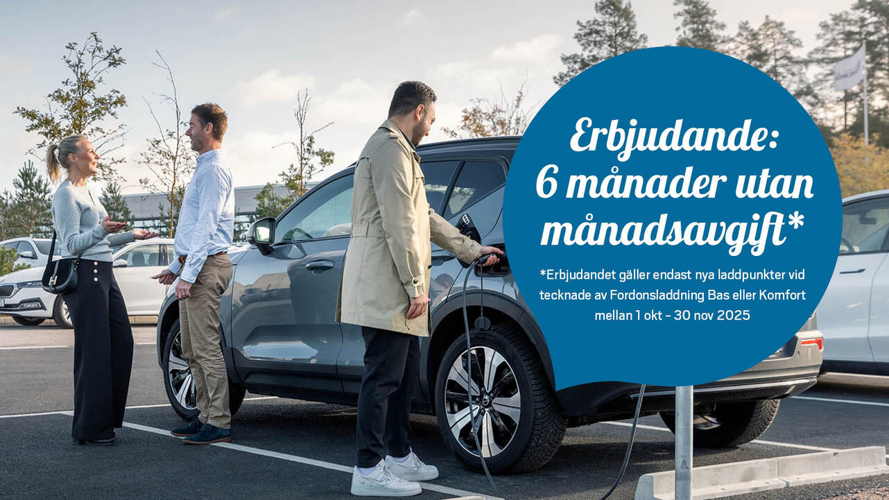 Tre personer står vid en grå SUV som laddas vid en elbilsladdstation på en parkeringsplats. En man ansluter laddkabeln till bilen medan de andra två samtalar bredvid. I bakgrunden syns fler parkerade bilar och träd under en molnig himmel. Med kampanjtext i blå cirkel: "Erbjudande: 6 månader utan månadsavgift*". Texten gäller nya laddpunkter vid avtal för Fordonsladdning Bas eller Komfort mellan 1 okt – 30 nov 2025.